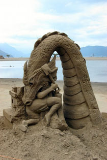 Arte in spiaggia: drago di sabbia divora l'artista!